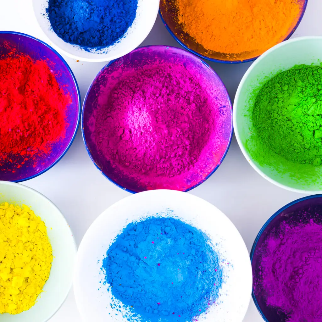 Vibrant turquoise and blue dye powders showing high concentration and purity for textile and paper applications.